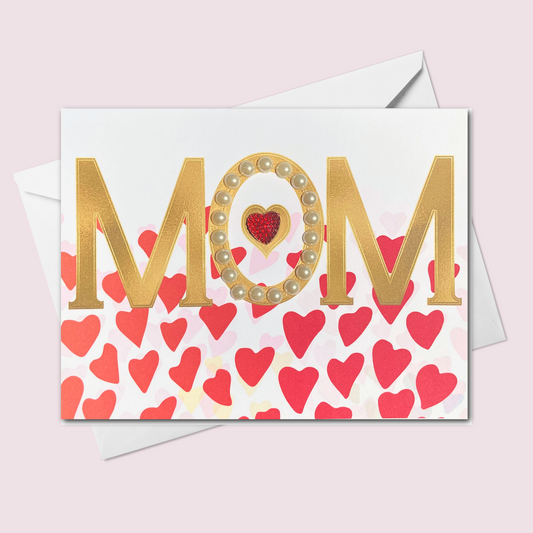 Handmade Mother's Day card featuring gold MOM letters with pearl accents, a glitter red heart, and a background of red and pink hearts, made in Canada.