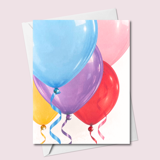 Russell Jeffrey Design greeting card featuring colourful balloons, curling ribbons and matching jewel accents, shown with a white envelope.